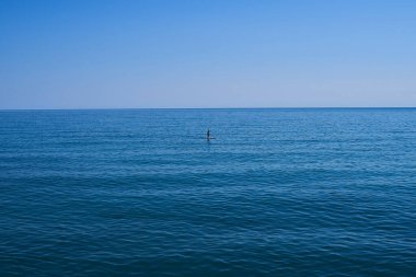 Denizdeki sörf tahtasındaki adam.