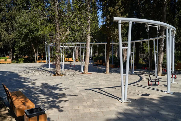 Baharda öğleden sonra boş bir park, çocuklar olmadan salıncak, parkta kimse yok, karantina