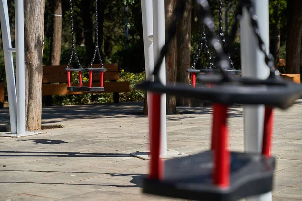 Baharda öğleden sonra boş bir park, çocuklar olmadan salıncak, parkta kimse yok, karantina
