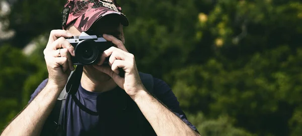 Man Cap Holds Camera His Hands Takes Pictures — Stock Photo, Image