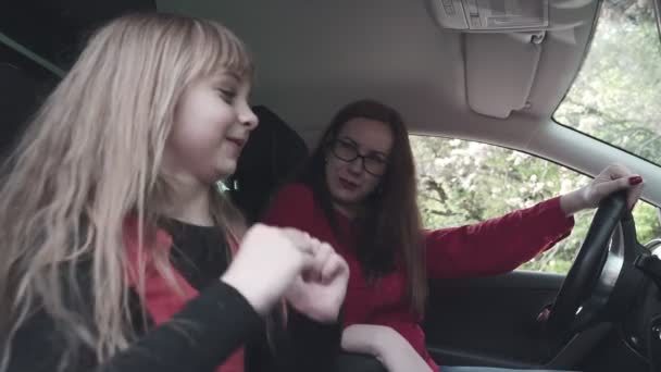 Família no carro. Mãe e filha menina juntos no carro se alegram e dançam para a música . — Vídeo de Stock