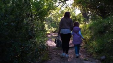 Anne ve kızı baharda parkta yürürler, yol boyunca yürürler ve birbirleriyle konuşurlar..