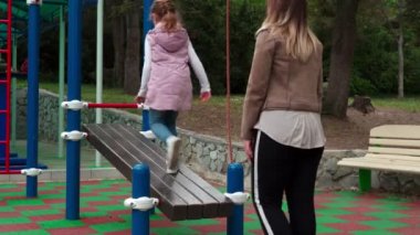 Anne ve kızı açık hava sporları parkında alıştırma yapıyor..