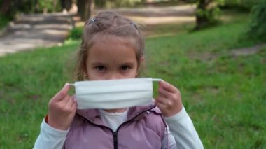Küçük kız koruyucu bir tıbbi maske takıyor.