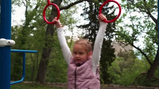Μητέρα και κόρη κάνουν ασκήσεις στην υπαίθρια παιδική χαρά αθλητισμού. — Αρχείο Βίντεο