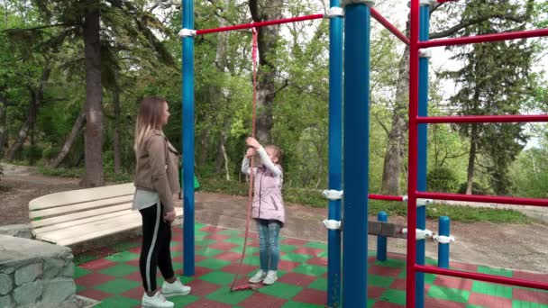 Mother and daughter doing exercises on open air sport playground. — Stock Video