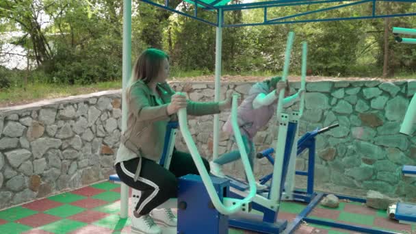 Anne ve kızı açık hava sporları parkında alıştırma yapıyor.. — Stok video
