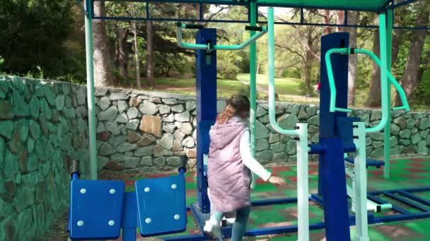 Madre e hija haciendo ejercicios en el patio de recreo deportivo al aire libre . — Vídeo de stock