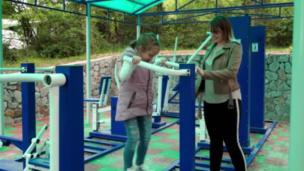 Mère et fille faisant des exercices sur terrain de sport en plein air . — Video