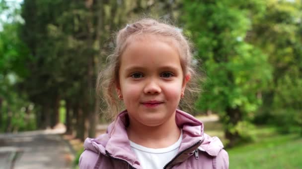 Portrait of joyful Caucasian little girl spending sunny spring day. — Stock Video
