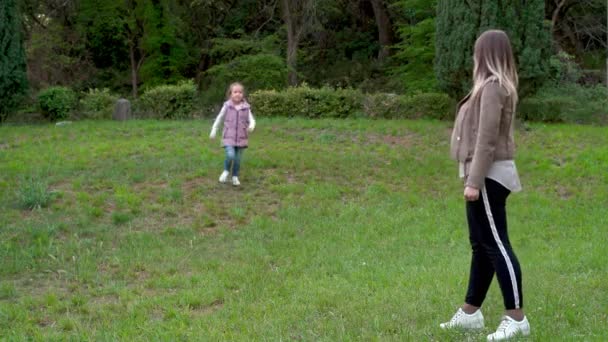 ビューティフルママと彼女の子供は一緒に公園で遊ぶ. — ストック動画