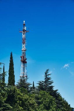 Gökyüzüne ve ağaçlara karşı eski şehir televizyon kulesi. Eski TV Kulesi.