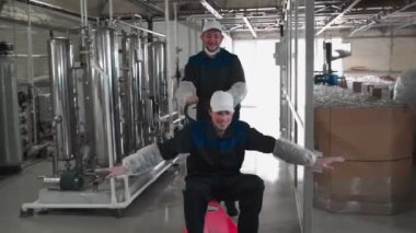 Saf su bitkisi. Tatildeki iki çalışan, atölyede hidrolik tramvaya binerken eğleniyor. 4k