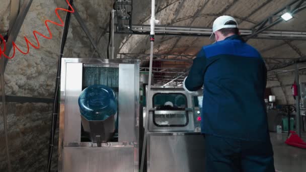 纯净水厂 身穿特殊制服和戴防护面具的男子与大瓶清洁饮用水一起工作 瓶装清洁饮用水的工作过程 — 图库视频影像