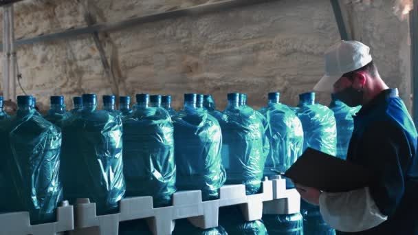 純水プラント 工場の従業員は きれいな飲料水で大瓶で完成品をチェックします — ストック動画