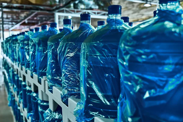 Saf içme suyu bitkisi. Sıraya dizilmiş büyük su şişeleri. 19 litre.