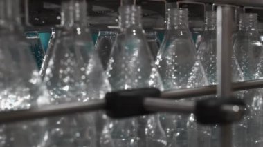 Saf içme suyu bitkisi. Girişimcilik için nakliyeci. Taşıyıcıdaki limon şişeleri suyla doldurulmuş, kapaklar ve yapıştırılmış etiketlerle kapatılmış. 4k