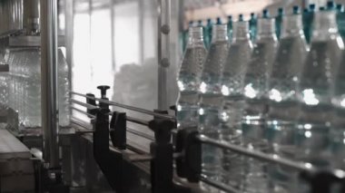 Saf içme suyu bitkisi. Girişimcilik için nakliyeci. Taşıyıcıdaki limon şişeleri suyla doldurulmuş, kapaklar ve yapıştırılmış etiketlerle kapatılmış. 4k
