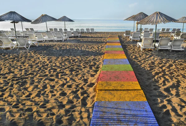 Buongiorno, Dawn. La pista sulla spiaggia di sabbia deserta vicino al mare. Lettini e ombrelloni — Foto Stock