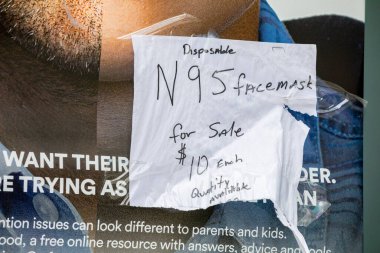 Manhattan, New York, ABD - 5 Nisan 2020: Manhattan 'da bir otobüs durağına bantlanmış şişirilmiş fiyatlarla N95 maskesi satan ev yapımı bir tabela.