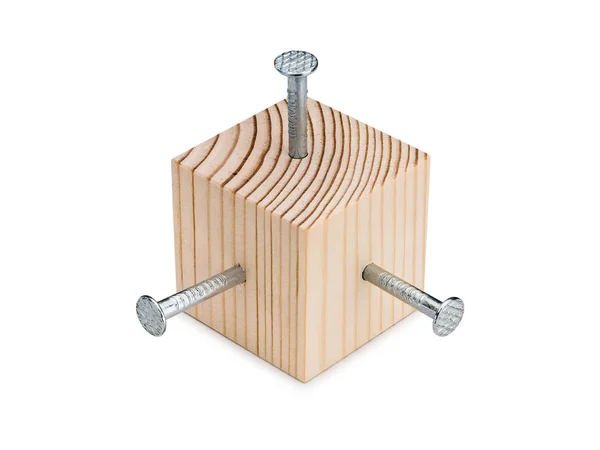 Trä kub och tre stål spikning — Stockfoto