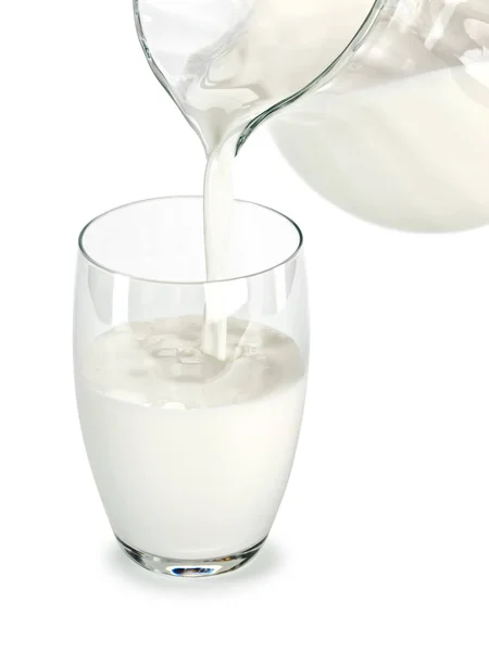 Füllung eines Glases mit Milch aus einem Glaskrug — Stockfoto
