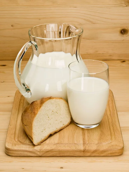 Кусок белого хлеба и посуда, наполненная молоком — стоковое фото