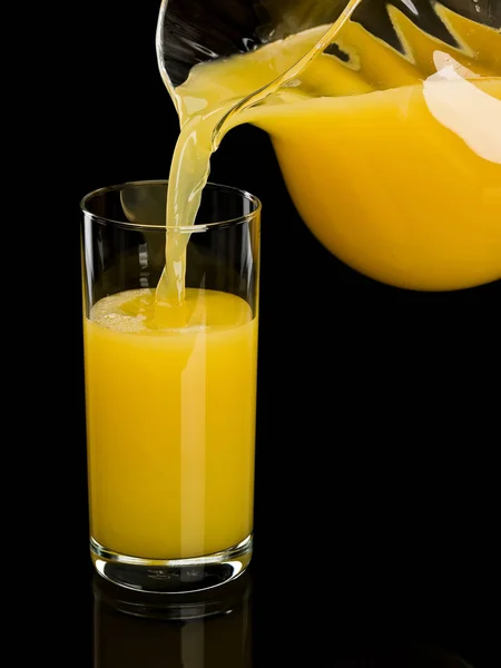 Enchimento de um copo pelo suco de laranja — Fotografia de Stock