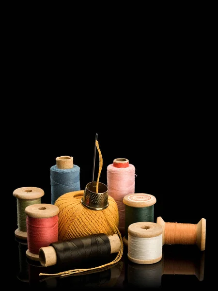 Group of old coils with multi-colored threads and needle with th — Stock Photo, Image