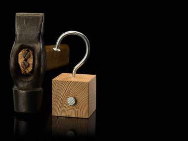 Eski çekiç, tahta küp ve içine iki çelik çivi çakılmış, siyah üzerinde izole edilmiş. 