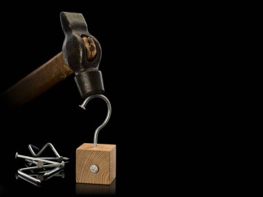 Eski çekiç, tahta küp ve yamuk çivilerden oluşan bir grup, siyah üzerinde izole edilmiş. 