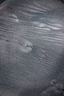 Dramatik siyah, tek renkli soyutlama, ejderha pullarını ya da kek lavlarını anımsatıyor, koyu gri, gümüş ve bronz aksanlarla parıldıyor. Alkolik mürekkep birbirine karışıyor. Modern bir sanat eserinin parçası..