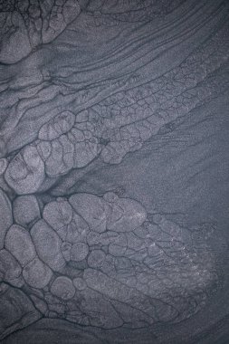 Dramatik siyah, tek renkli soyutlama, ejderha pullarını ya da kek lavlarını anımsatıyor, koyu gri, gümüş ve bronz aksanlarla parıldıyor. Alkolik mürekkep birbirine karışıyor. Modern bir sanat eserinin parçası..