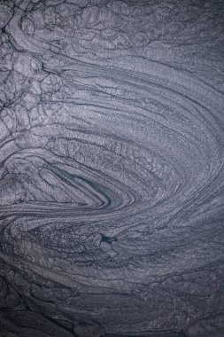 Dramatik siyah, tek renkli soyutlama, ejderha pullarını ya da kek lavlarını anımsatıyor, koyu gri, gümüş ve bronz aksanlarla parıldıyor. Alkolik mürekkep birbirine karışıyor. Modern bir sanat eserinin parçası..