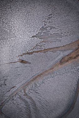 Dramatik siyah, tek renkli soyutlama, ejderha pullarını ya da kek lavlarını anımsatıyor, koyu gri, gümüş ve bronz aksanlarla parıldıyor. Alkolik mürekkep birbirine karışıyor. Modern bir sanat eserinin parçası..