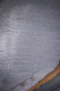 Dramatik siyah, tek renkli soyutlama, ejderha pullarını ya da kek lavlarını anımsatıyor, koyu gri, gümüş ve bronz aksanlarla parıldıyor. Alkolik mürekkep birbirine karışıyor. Modern bir sanat eserinin parçası..