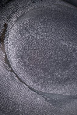 Dramatik siyah, tek renkli soyutlama, ejderha pullarını ya da kek lavlarını anımsatıyor, koyu gri, gümüş ve bronz aksanlarla parıldıyor. Alkolik mürekkep birbirine karışıyor. Modern bir sanat eserinin parçası..