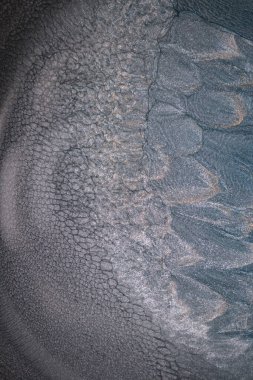 Dramatik siyah, tek renkli soyutlama, ejderha pullarını ya da kek lavlarını anımsatıyor, koyu gri, gümüş ve bronz aksanlarla parıldıyor. Alkolik mürekkep birbirine karışıyor. Modern bir sanat eserinin parçası..