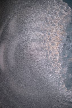 Dramatik siyah, tek renkli soyutlama, ejderha pullarını ya da kek lavlarını anımsatıyor, koyu gri, gümüş ve bronz aksanlarla parıldıyor. Alkolik mürekkep birbirine karışıyor. Modern bir sanat eserinin parçası..