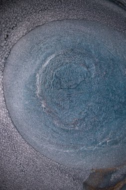 Dramatik siyah, tek renkli soyutlama, ejderha pullarını ya da kek lavlarını anımsatıyor, koyu gri, gümüş ve bronz aksanlarla parıldıyor. Alkolik mürekkep birbirine karışıyor. Modern bir sanat eserinin parçası..