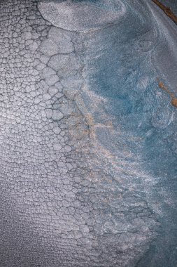 Dramatik siyah, tek renkli soyutlama, ejderha pullarını ya da kek lavlarını anımsatıyor, koyu gri, gümüş ve bronz aksanlarla parıldıyor. Alkolik mürekkep birbirine karışıyor. Modern bir sanat eserinin parçası..