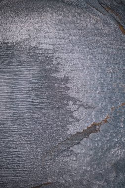 Dramatik siyah, tek renkli soyutlama, ejderha pullarını ya da kek lavlarını anımsatıyor, koyu gri, gümüş ve bronz aksanlarla parıldıyor. Alkolik mürekkep birbirine karışıyor. Modern bir sanat eserinin parçası..