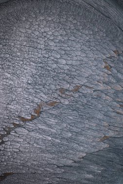 Dramatik siyah, tek renkli soyutlama, ejderha pullarını ya da kek lavlarını anımsatıyor, koyu gri, gümüş ve bronz aksanlarla parıldıyor. Alkolik mürekkep birbirine karışıyor. Modern bir sanat eserinin parçası..