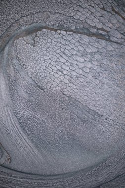 Dramatik siyah, tek renkli soyutlama, ejderha pullarını ya da kek lavlarını anımsatıyor, koyu gri, gümüş ve bronz aksanlarla parıldıyor. Alkolik mürekkep birbirine karışıyor. Modern bir sanat eserinin parçası..