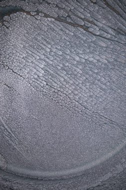 Dramatik siyah, tek renkli soyutlama, ejderha pullarını ya da kek lavlarını anımsatıyor, koyu gri, gümüş ve bronz aksanlarla parıldıyor. Alkolik mürekkep birbirine karışıyor. Modern bir sanat eserinin parçası..