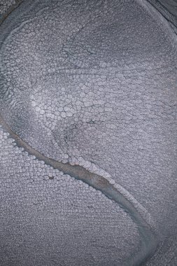 Dramatik siyah, tek renkli soyutlama, ejderha pullarını ya da kek lavlarını anımsatıyor, koyu gri, gümüş ve bronz aksanlarla parıldıyor. Alkolik mürekkep birbirine karışıyor. Modern bir sanat eserinin parçası..