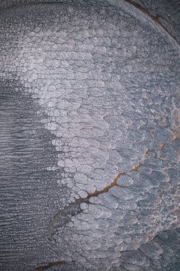 Dramatik siyah, tek renkli soyutlama, ejderha pullarını ya da kek lavlarını anımsatıyor, koyu gri, gümüş ve bronz aksanlarla parıldıyor. Alkolik mürekkep birbirine karışıyor. Modern bir sanat eserinin parçası..