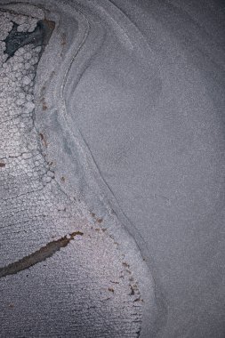 Dramatik siyah, tek renkli soyutlama, ejderha pullarını ya da kek lavlarını anımsatıyor, koyu gri, gümüş ve bronz aksanlarla parıldıyor. Alkolik mürekkep birbirine karışıyor. Modern bir sanat eserinin parçası..