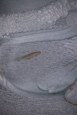 Dramatik siyah, tek renkli soyutlama, ejderha pullarını ya da kek lavlarını anımsatıyor, koyu gri, gümüş ve bronz aksanlarla parıldıyor. Alkolik mürekkep birbirine karışıyor. Modern bir sanat eserinin parçası..