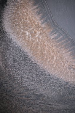 Dramatik siyah, tek renkli soyutlama, ejderha pullarını ya da kek lavlarını anımsatıyor, koyu gri, gümüş ve bronz aksanlarla parıldıyor. Alkolik mürekkep birbirine karışıyor. Modern bir sanat eserinin parçası..